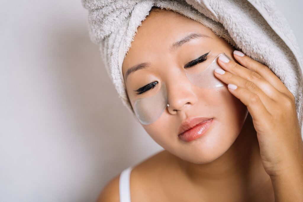 Woman applying cooling under-eye patches as part of a relaxing nighttime self-care routine