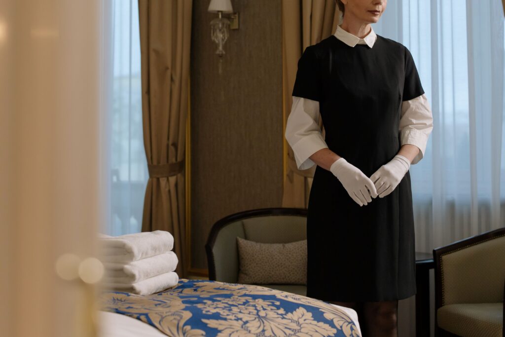 Hotel housekeeper standing in a guest room prepared for new arrivals