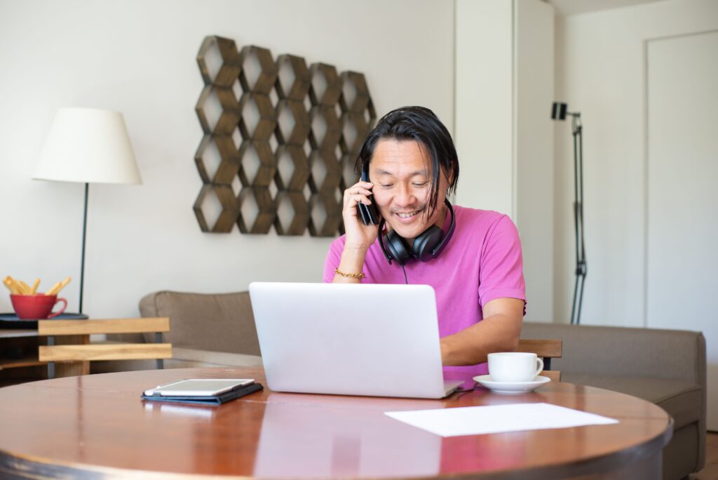 Person working remotely from home using a laptop while taking a business call in Japan