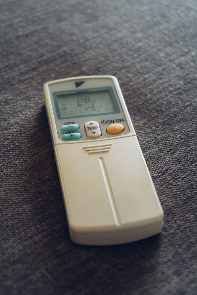 Air conditioner remote control set to cooling mode to help maintain a comfortable indoor temperature for pets.