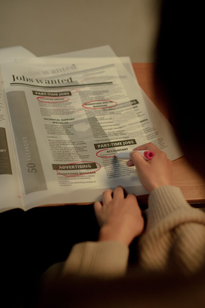 Job seeker reviewing and highlighting part-time job listings in a newspaper