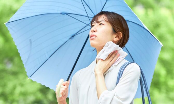 Woman staying cool under a parasol during Japan's hot and humid summer