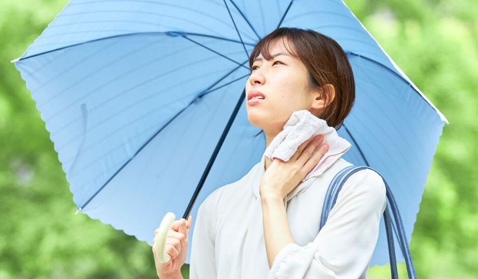 Woman staying cool under a parasol during Japan's hot and humid summer