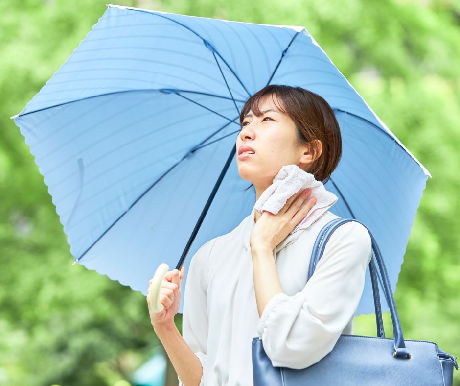 Woman staying cool under a parasol during Japan's hot and humid summer