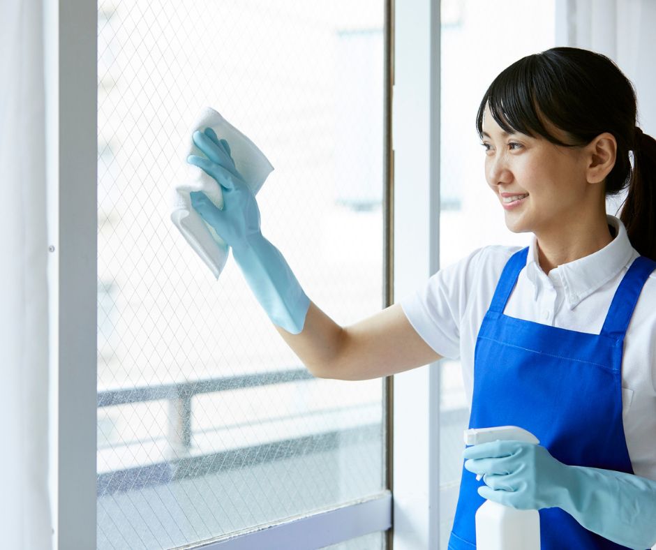 Cleaning window screens in a Japanese apartment to help keep mosquitoes and other summer bugs from entering the home.