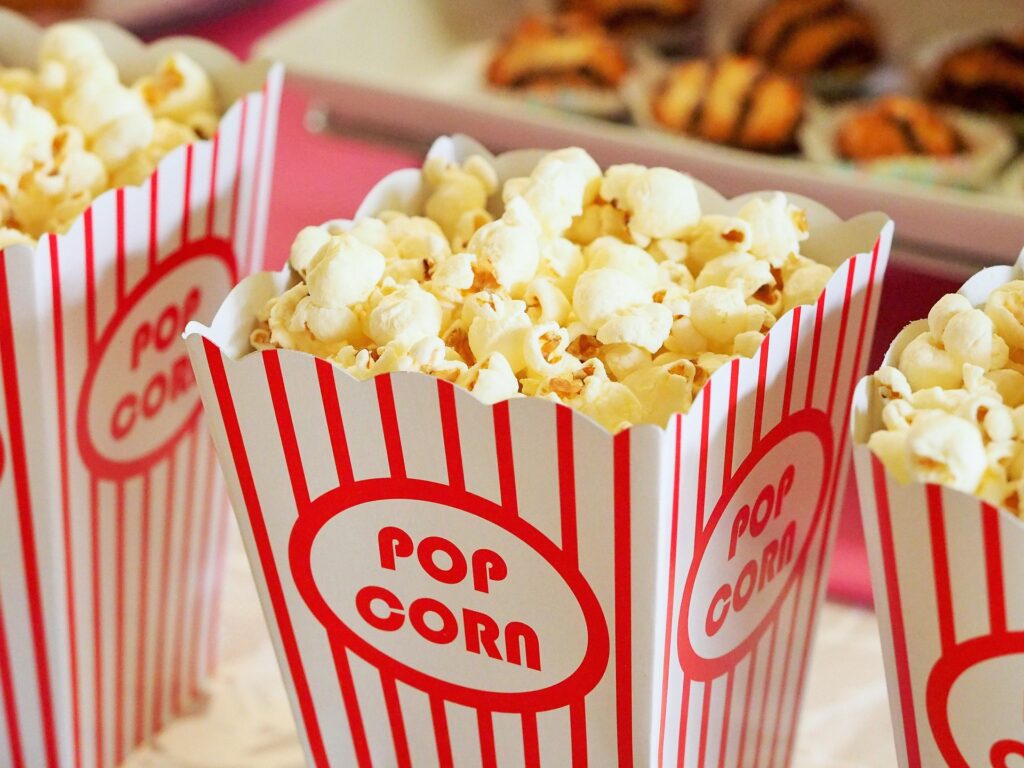 Freshly popped popcorn in classic red-and-white striped containers, bringing back the nostalgic movie theater experience often associated with American entertainment.