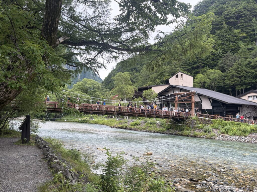Kappa-bashi Bridge spanning the crystal-clear Azusa River in Kamikochi surrounded by lush green mountains