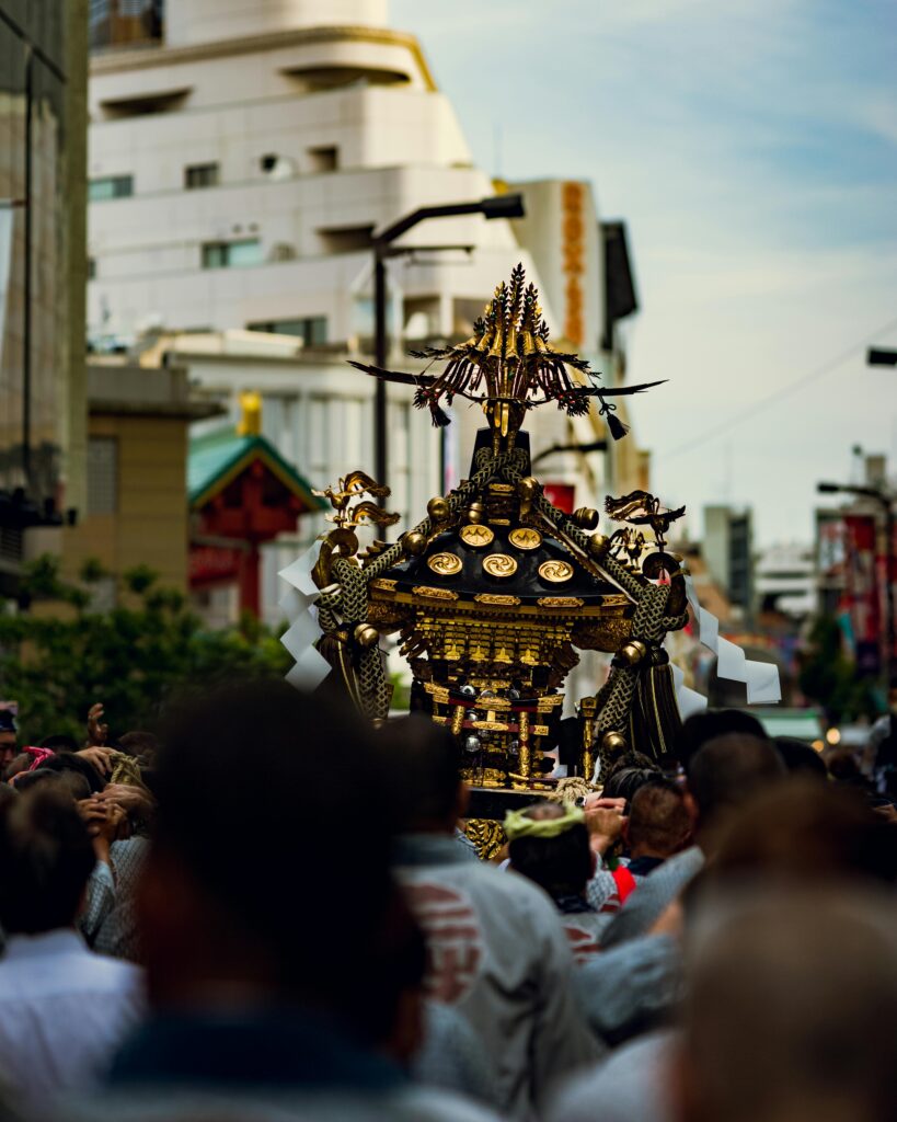 Festival participants carry a beautifully decorated mikoshi through crowded streets during a traditional Tokyo matsuri.