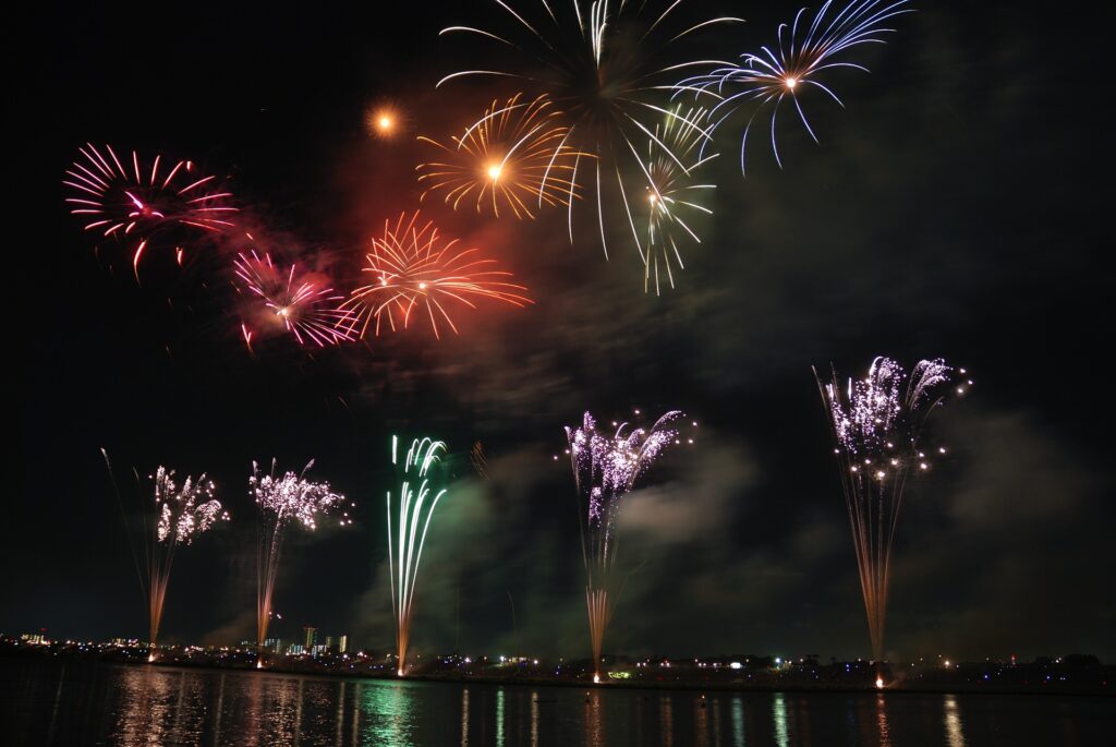 Fireworks over the water at a Japanese summer festival at night.