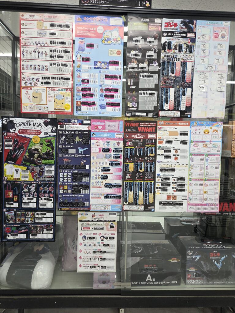 Store display featuring multiple Ichiban Kuji campaigns and prize boards for characters including Spider-Man, Godzilla, Sanrio, and Rilakkuma.