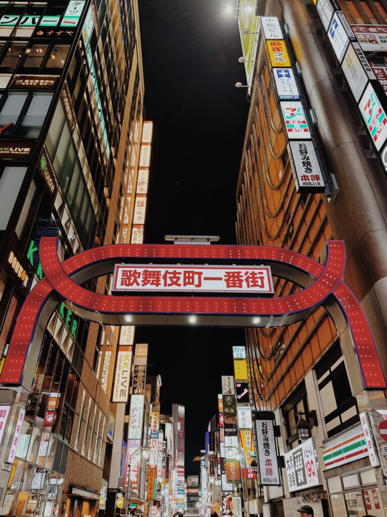 Kabukicho Ichibangai entrance gate surrounded by illuminated signs at night in Shinjuku, Tokyo.