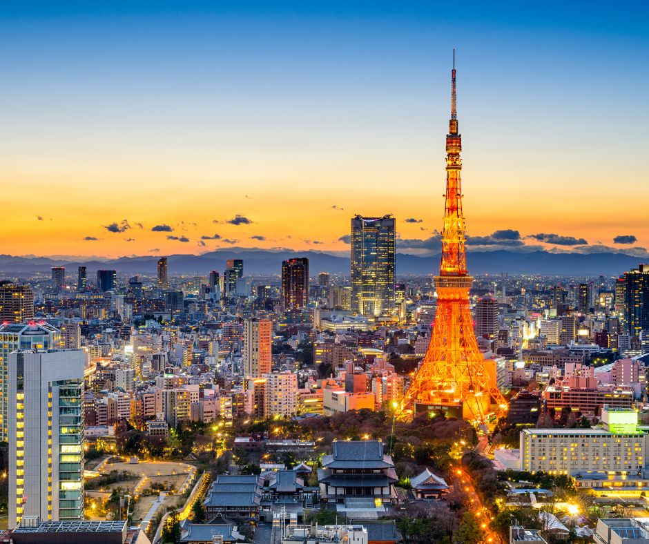 Tokyo Tower illuminated against a colorful sunset, overlooking Tokyo’s city skyline.
