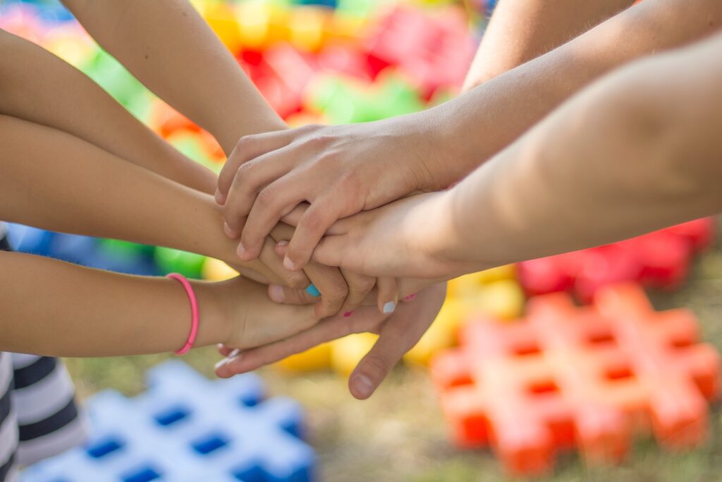 Children stacking their hands together during a group activity. 