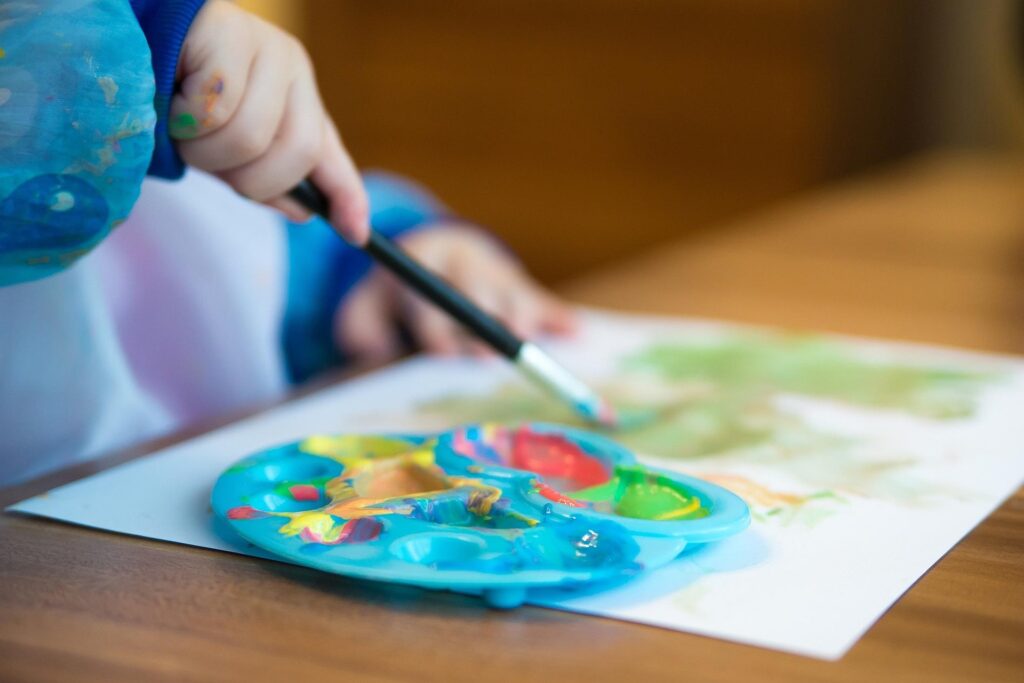 Young child painting a colorful picture during an art activity.
