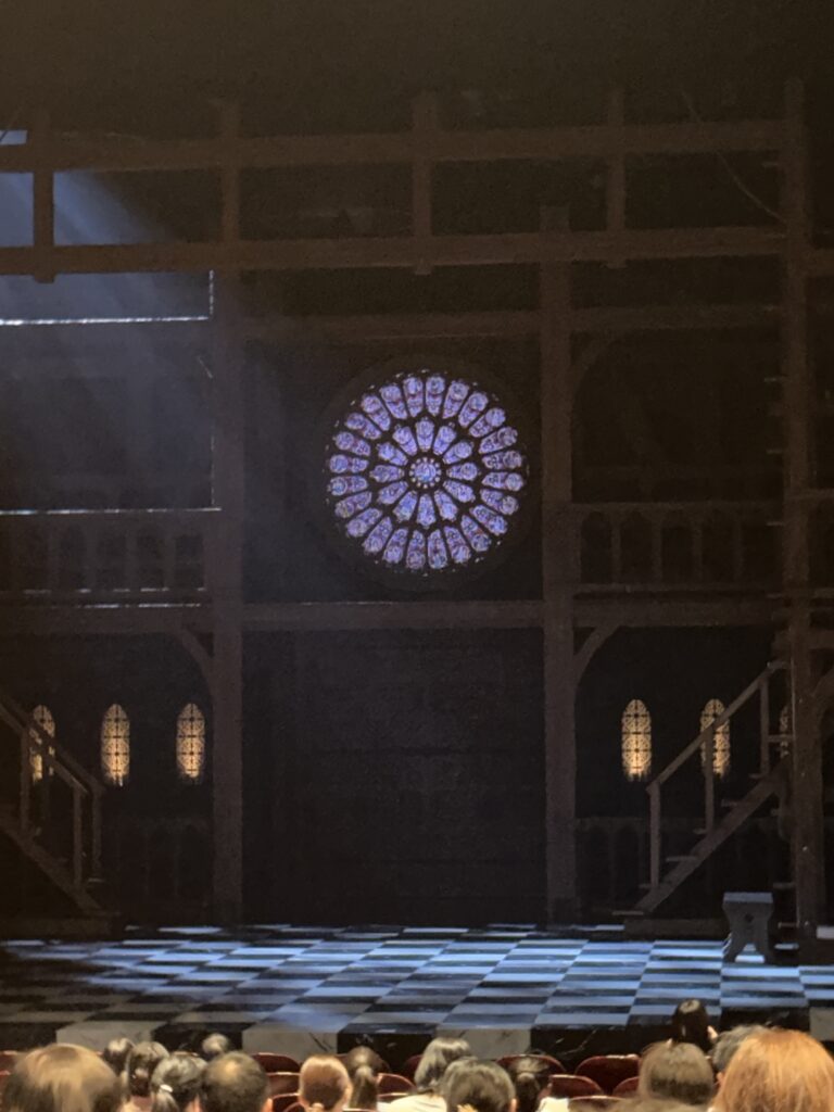 The Hunchback of Notre Dame stage at Osaka Shiki Theatre, featuring a Gothic cathedral set, stained-glass rose window, and checkered floor.