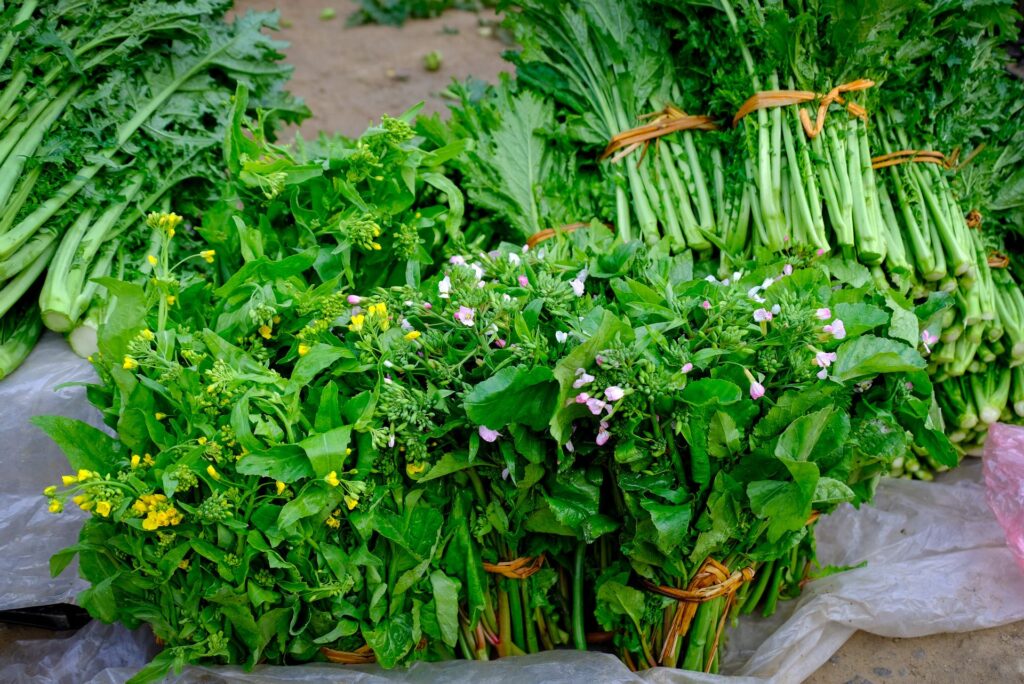 Fresh bundles of leafy green vegetables displayed at a local produce stand.