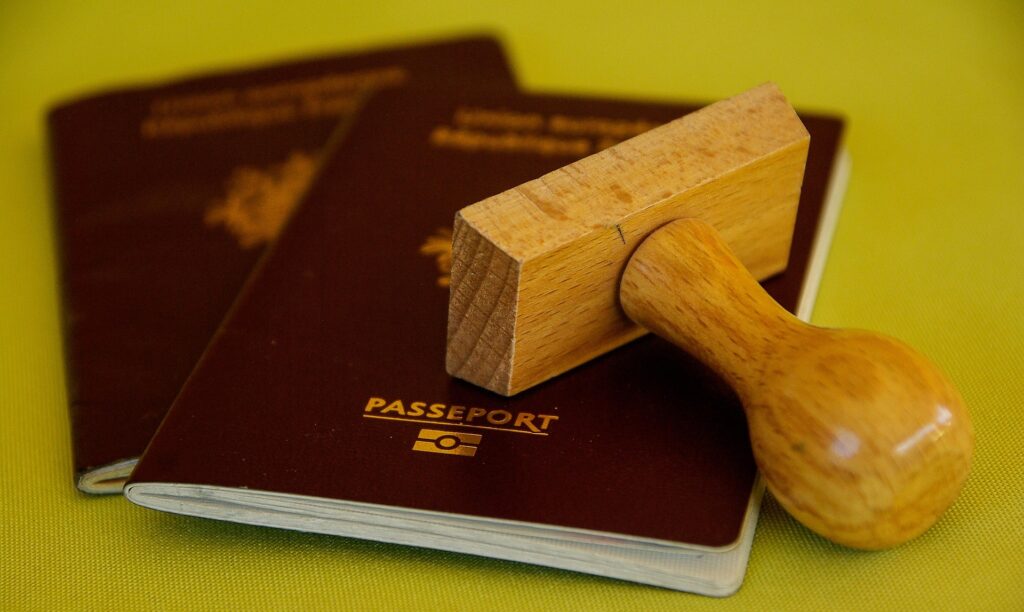 Passports with an immigration stamp, representing visa applications, residence procedures, and immigration requirements.