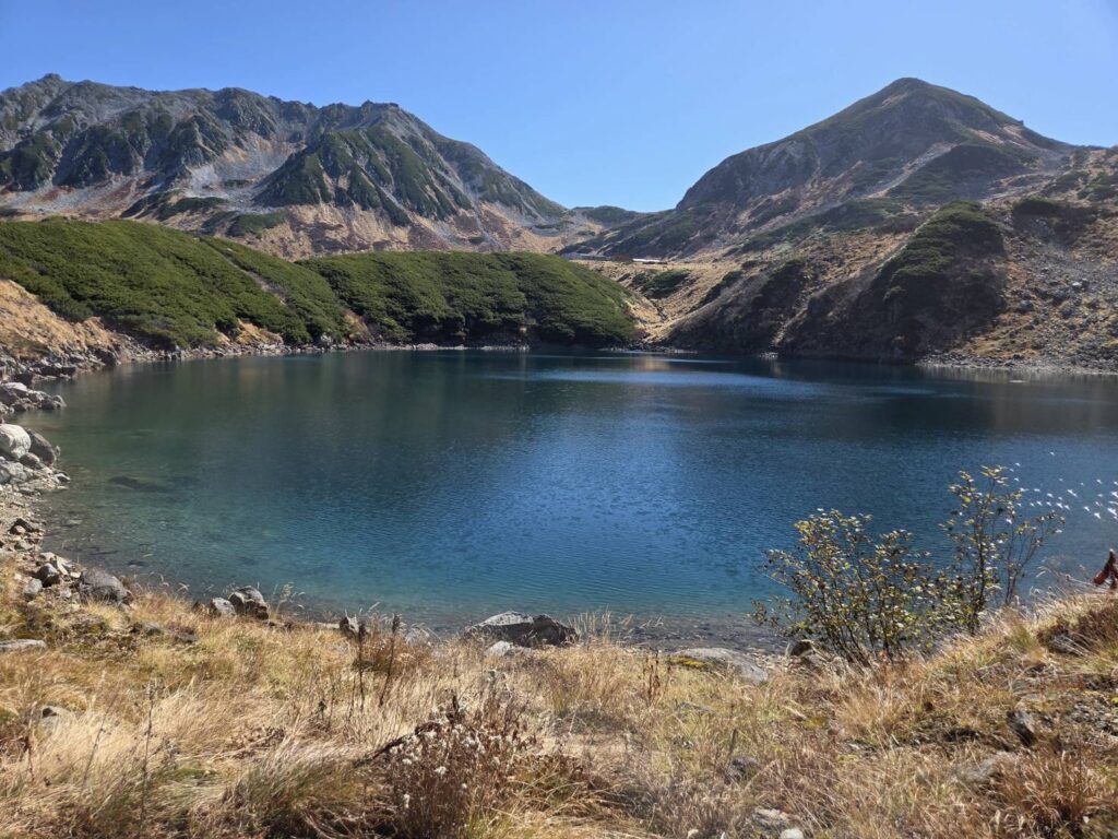 Stunning Mikurigaike Pond at Murodo, surrounded by rugged mountain peaks and beautiful autumn scenery in the Northern Japan Alps.