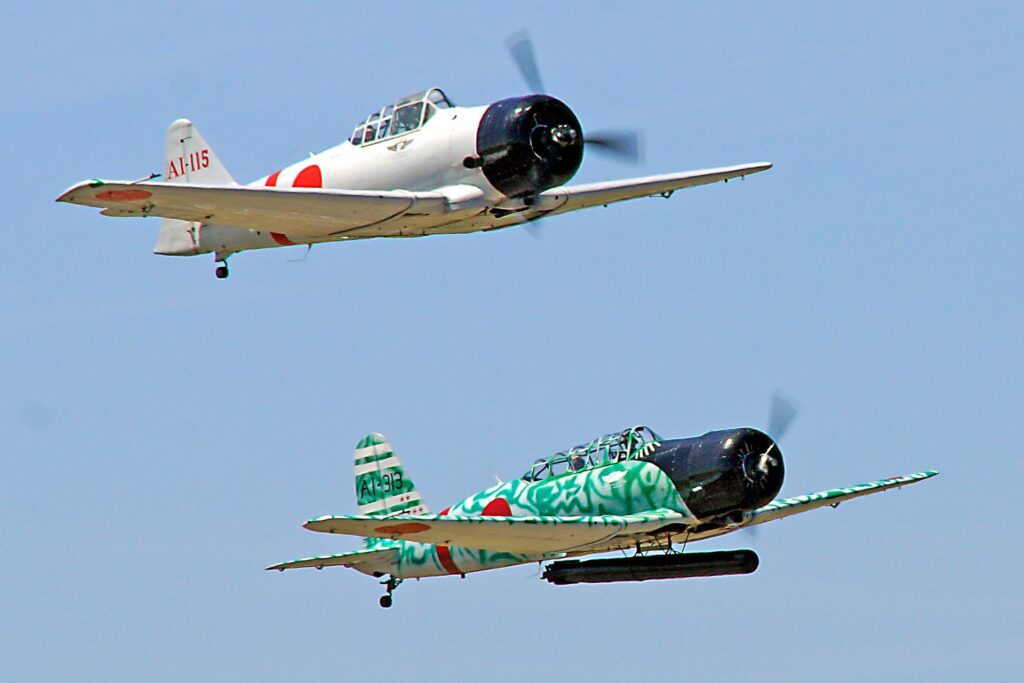Two vintage Japanese military aircraft flying against a clear blue sky, illustrating Japan's aviation history associated with Tokorozawa in Saitama.